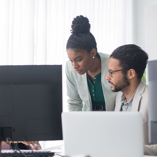 group of workers in office smiling at computer