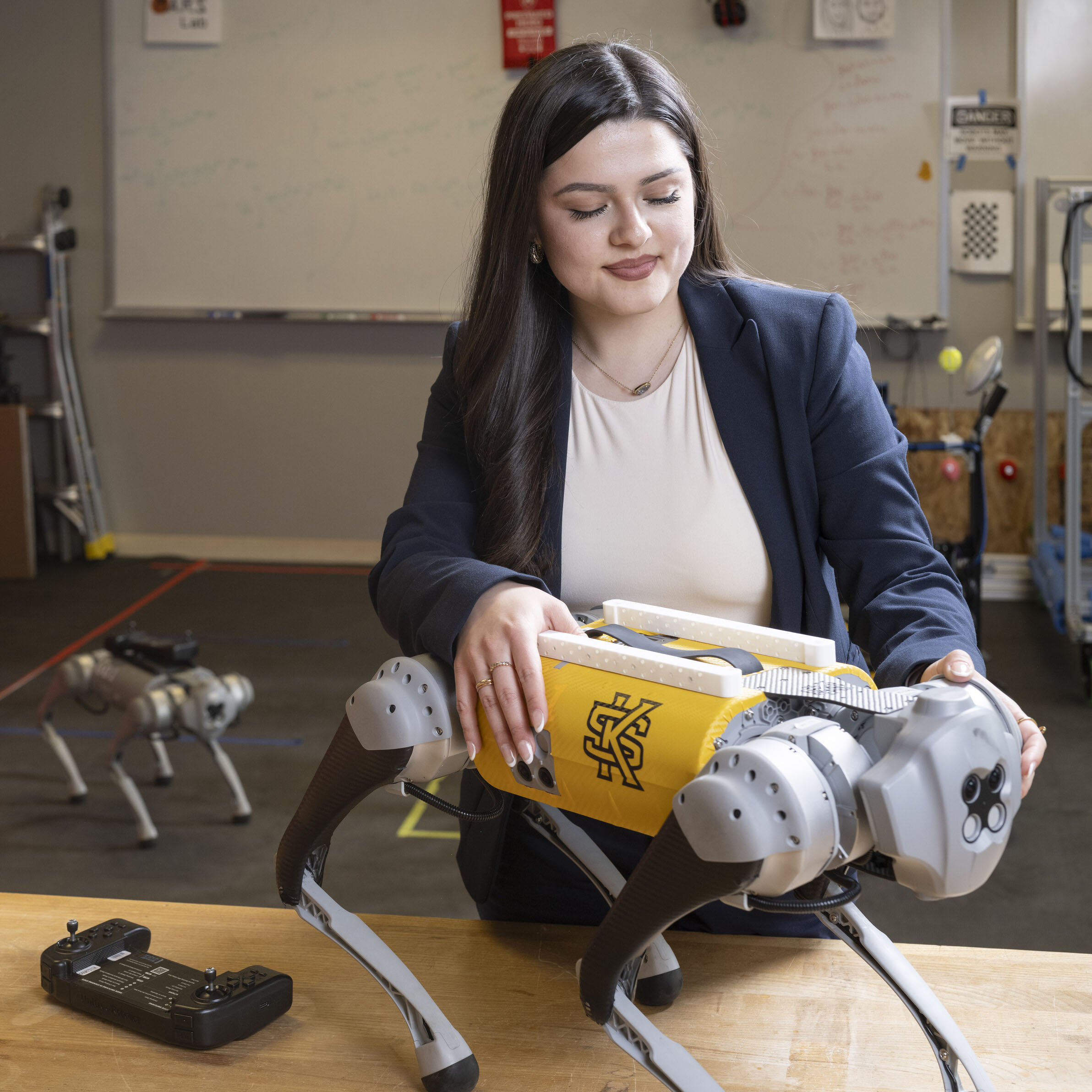 Female smiling as she works on robot in computer room