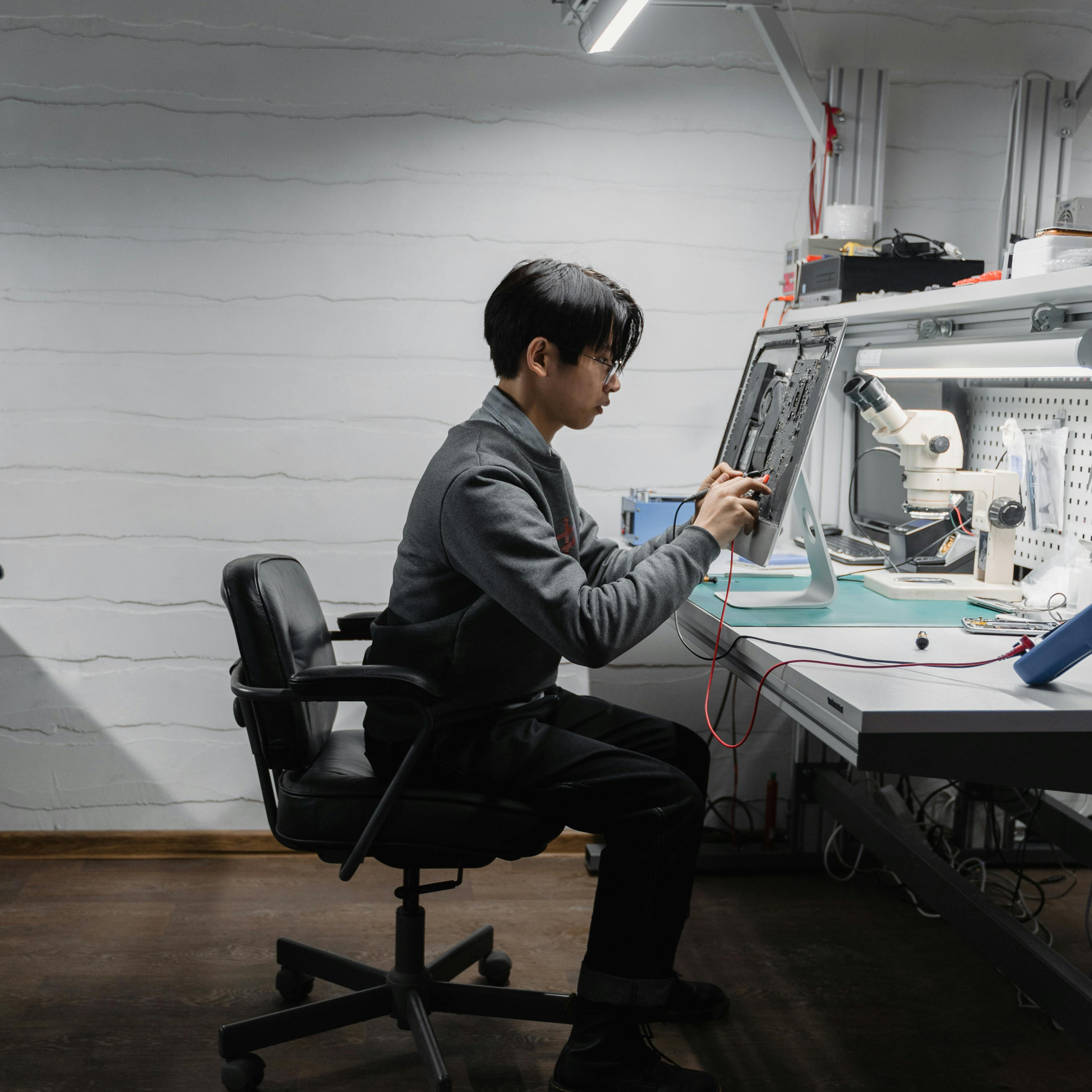 male sitting at automation desk working on robotics