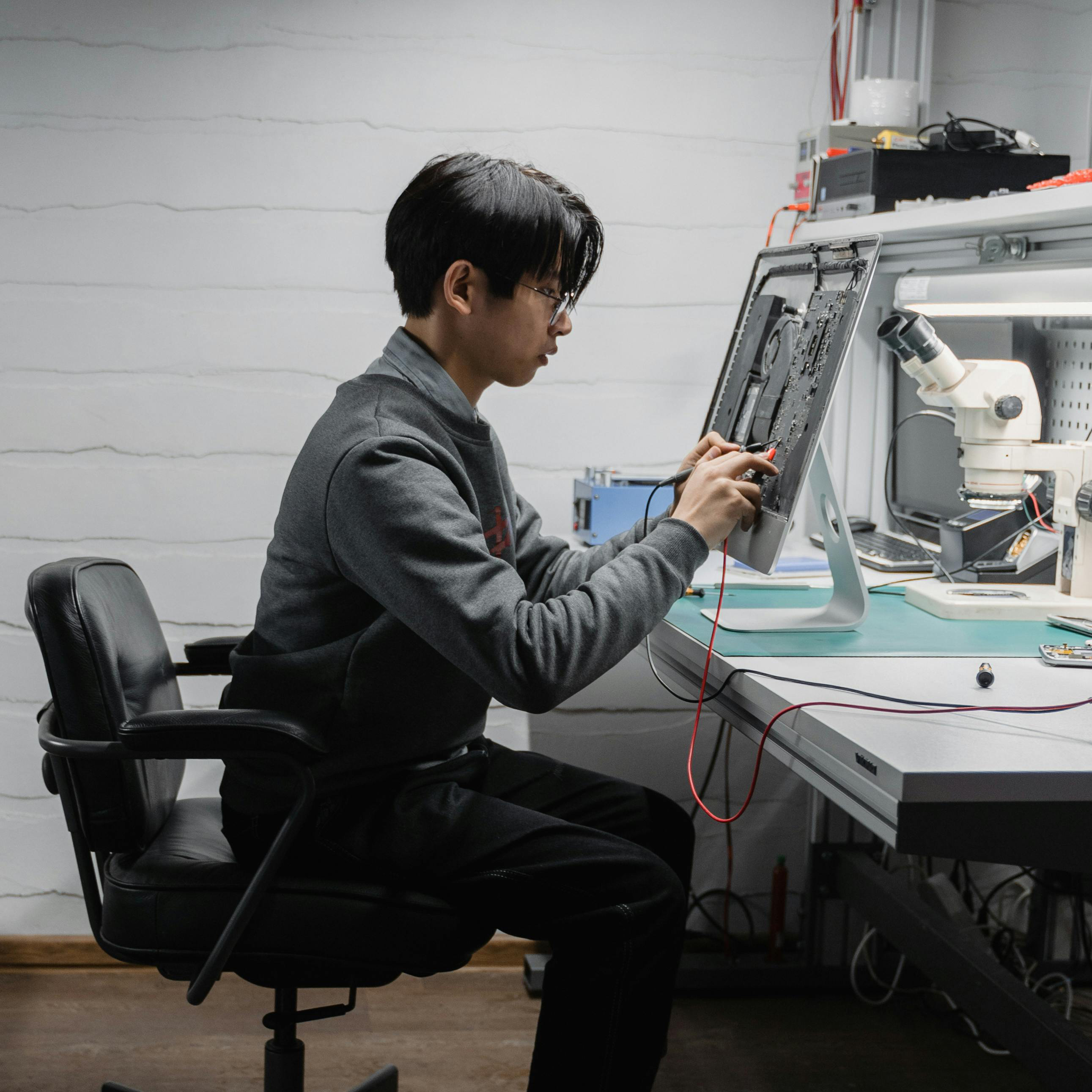 male sitting at automation desk working on robotics