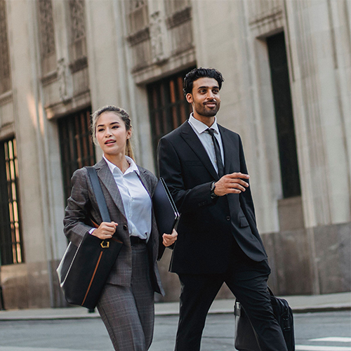 two business professional walking outside smiling
