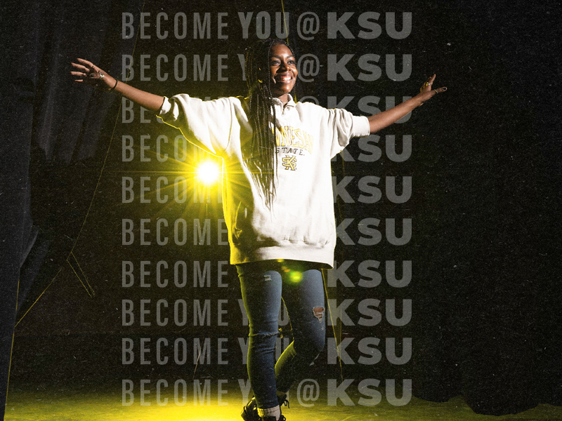 female african american in hoodie with arms open excited to be a ksu student
