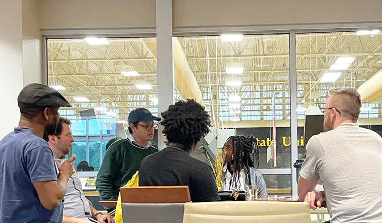 group of graduate students around a table at an event