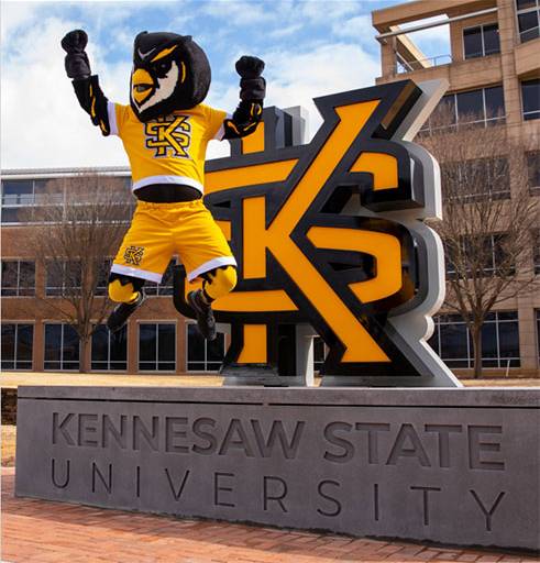 Scappy the owl jumping and celebrating next to the KSU Logo.