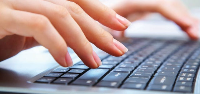 fingers typing on computer keyboard