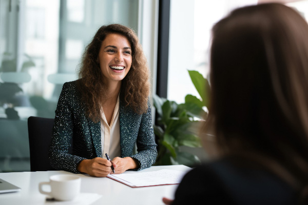 Smiling Female Manager Interviewing an Applicant In Office.