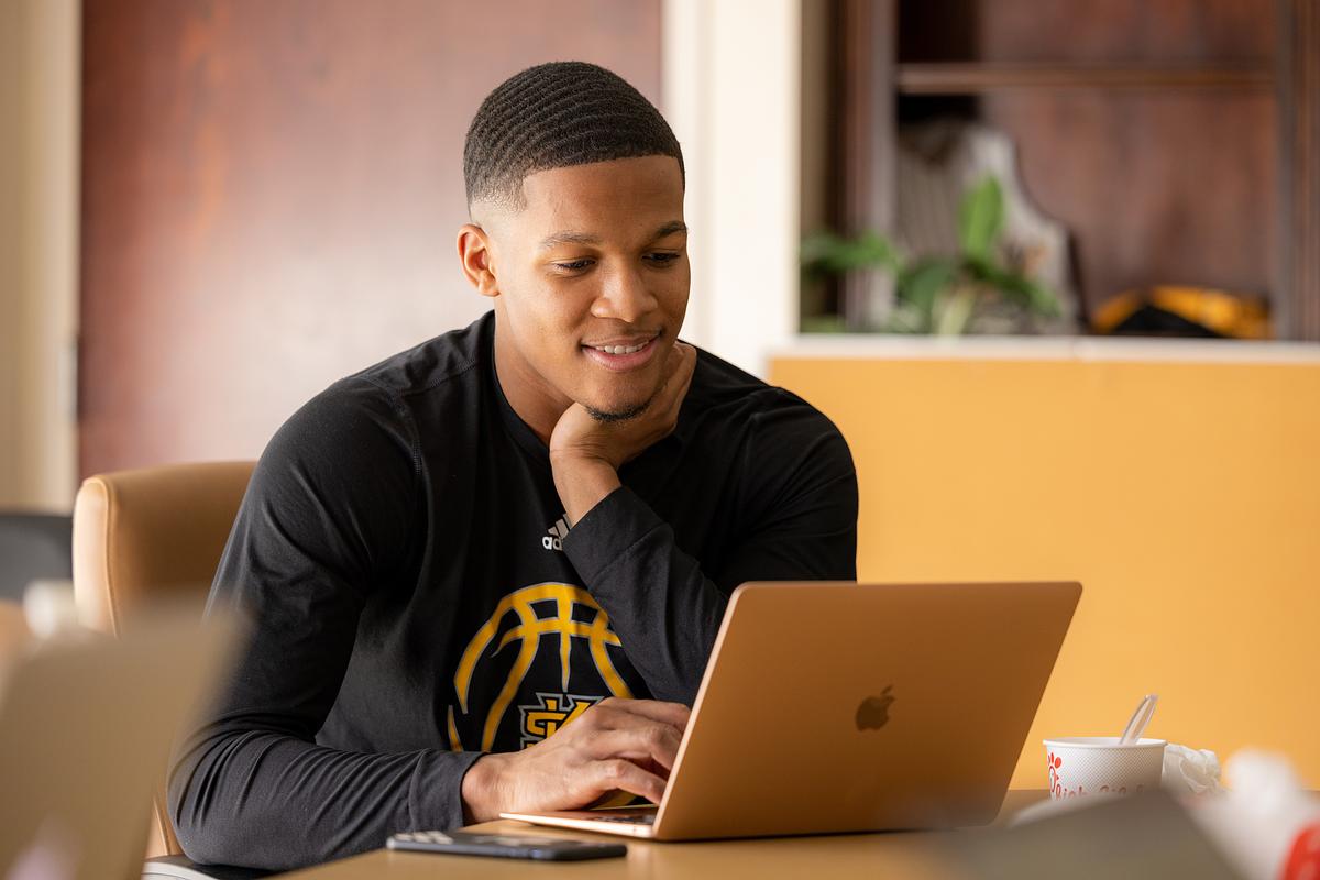 KSU student on his computer studying subject from core curriculum