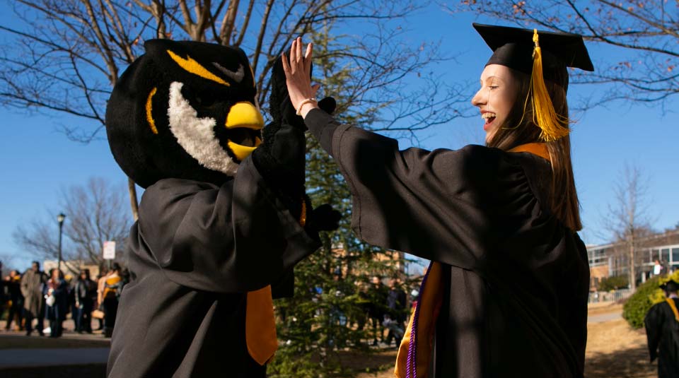 graduating student giving scrappy a high-five