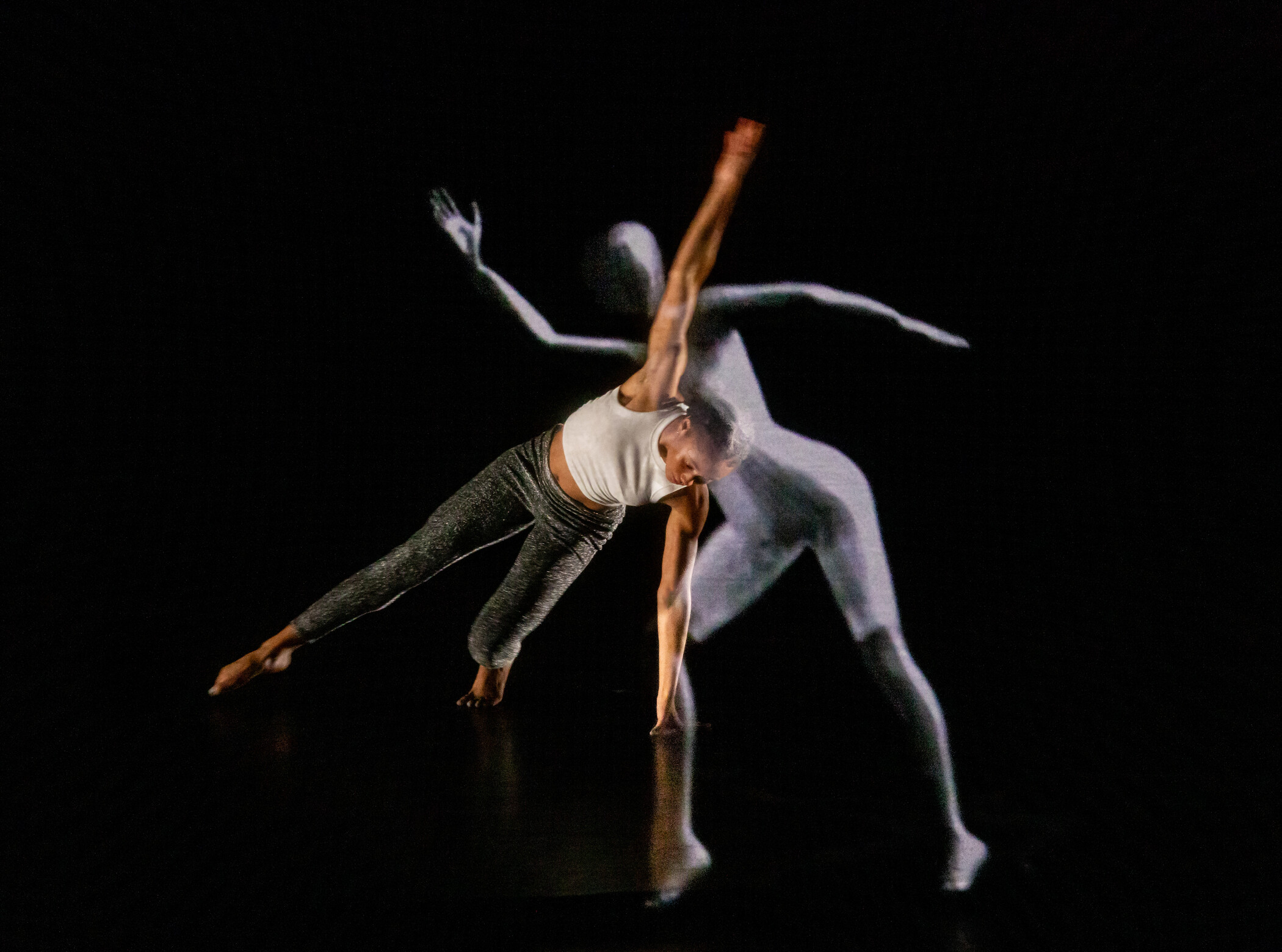 two ballet dancers dacing on black stage