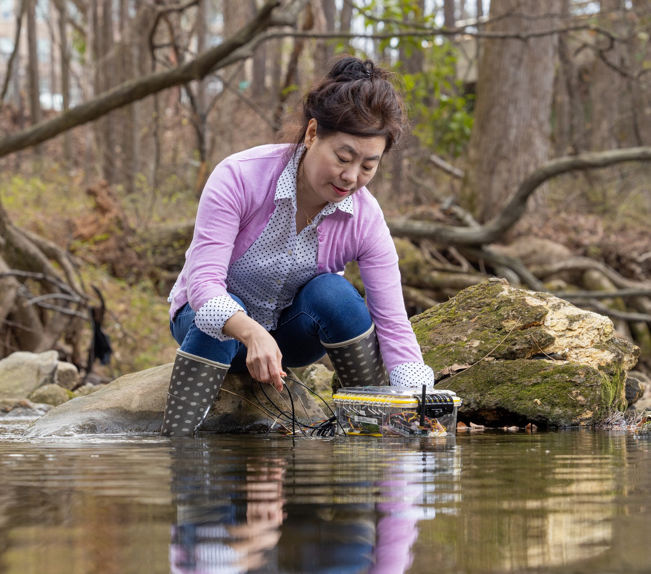 female doing research in a lake to understand water life