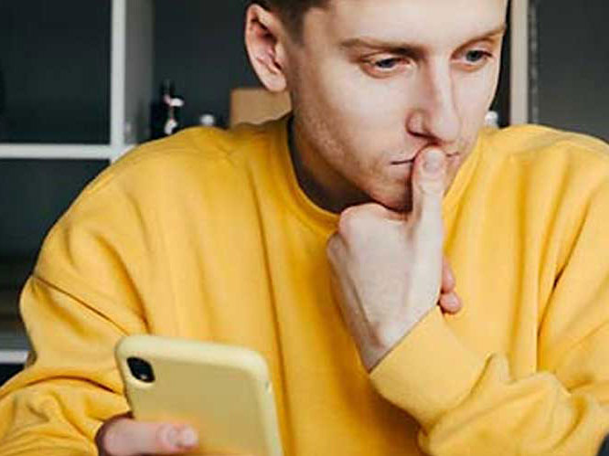 Man is holding phone in his hand and trying to focus