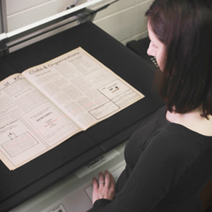 Researcher using an over head scanner to digitize collection materials
