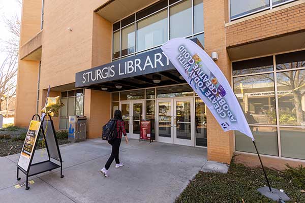 student walking up to the entrance of the sturgis library.