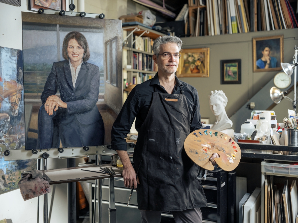 Artist Shane McDonald with his portrait of President Schwaig in his art studio