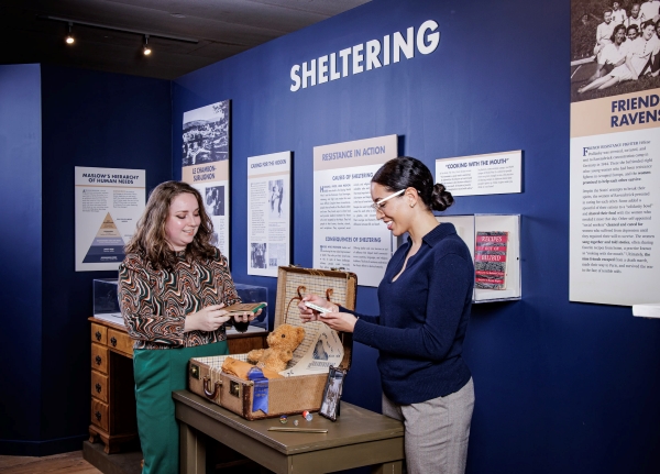 Two women examining a museum exhibit table