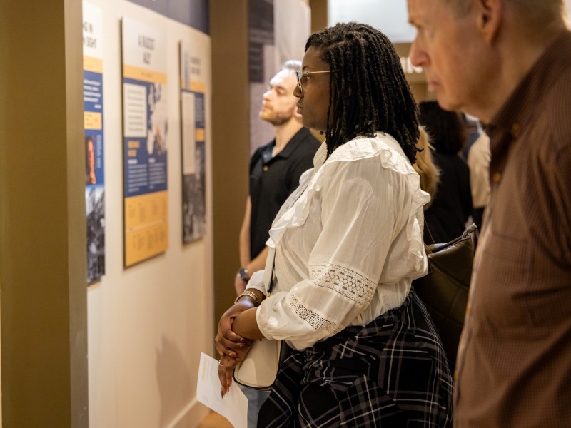 Several museum visitors looking at exhibition panels