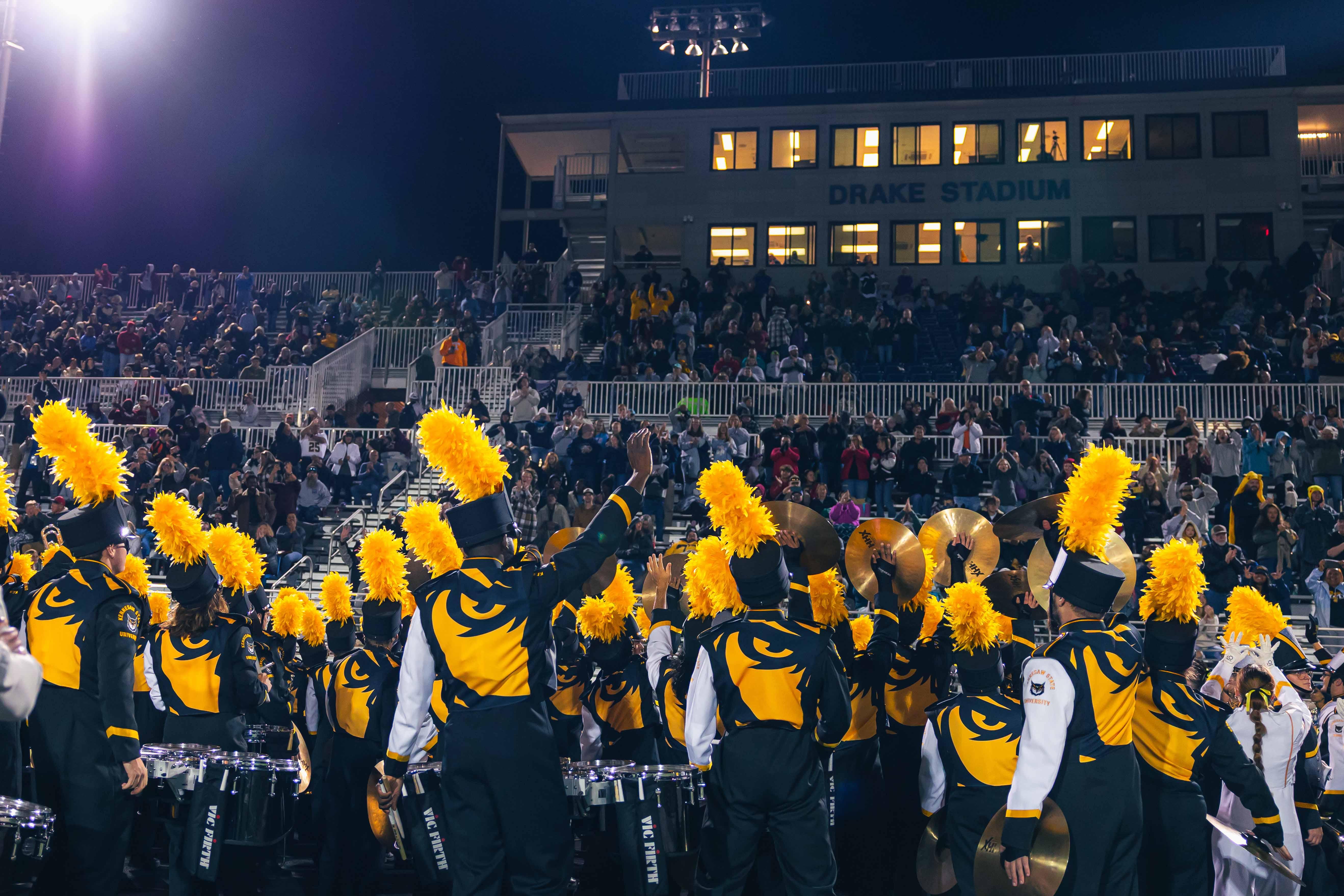 KSU's 2026 Marching Band / Pictures of KSU's marching band in uniform playing at a game with school spirit.