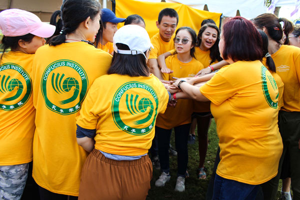 A group of people putting their hands in the center of a circle.