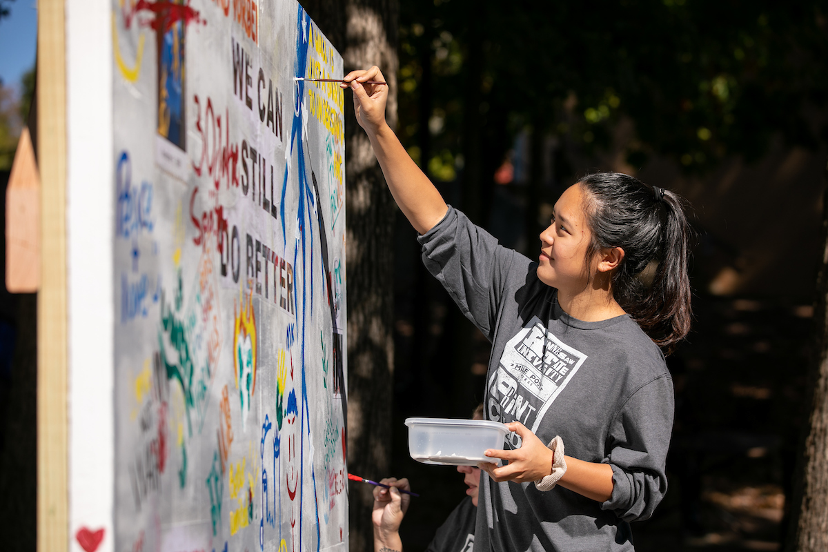 A KSU student paints a replica piece of the Berlin Wall