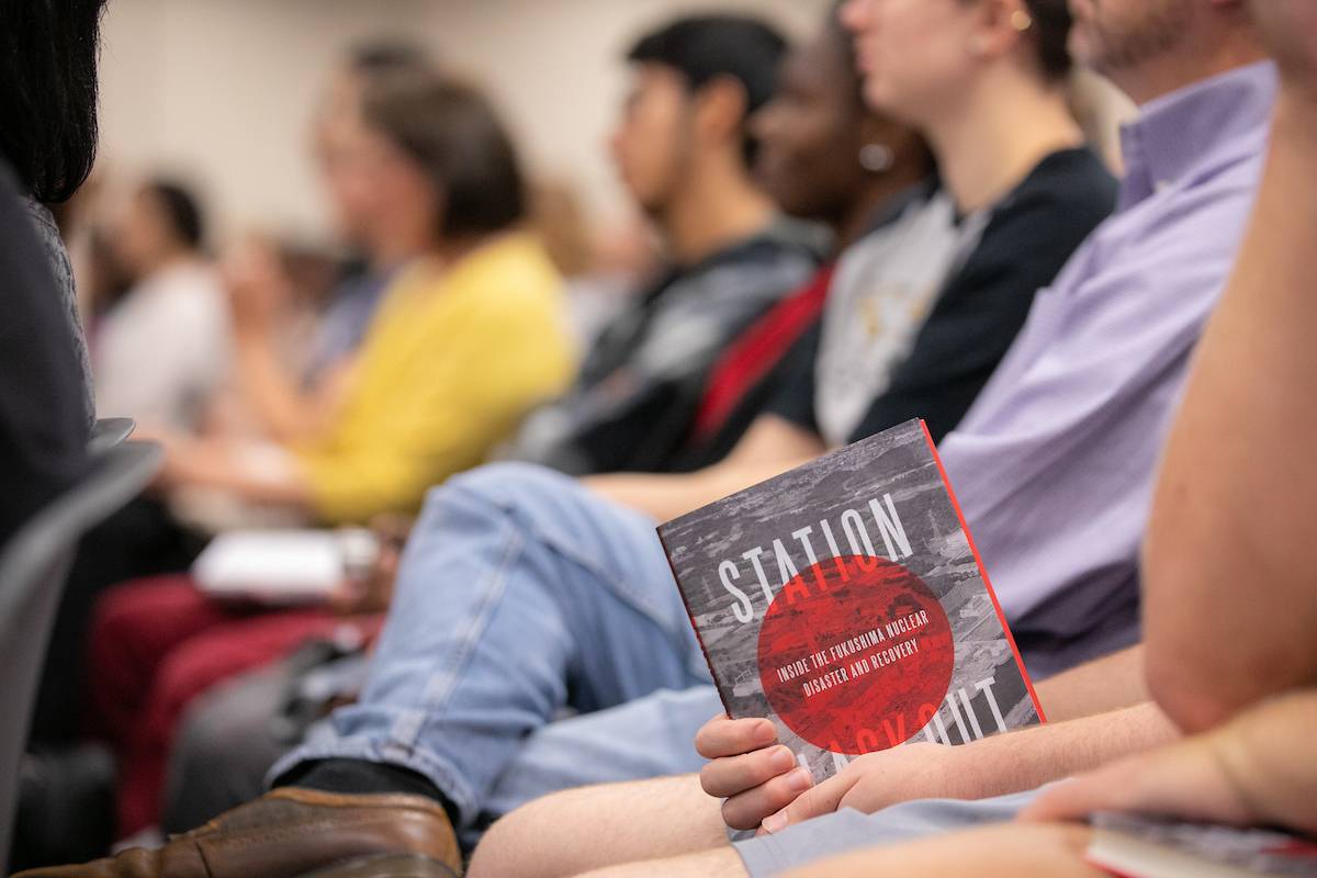 Students hold a copy of KSU alum Charles Castro’s book, Station Blackout