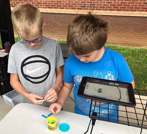 Photo of students standing in front of iTeach Makerbus