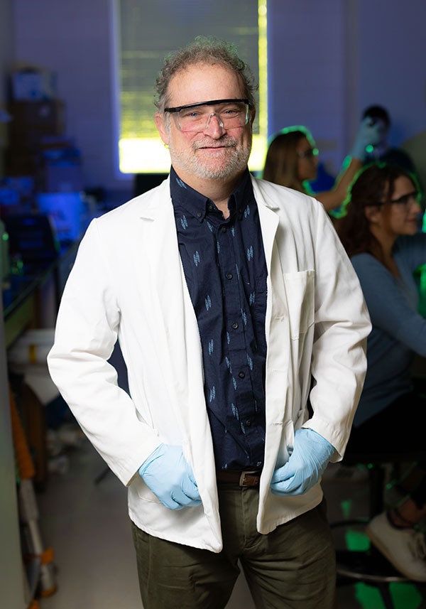 Photo of Thomas McElroy in lab with students in background