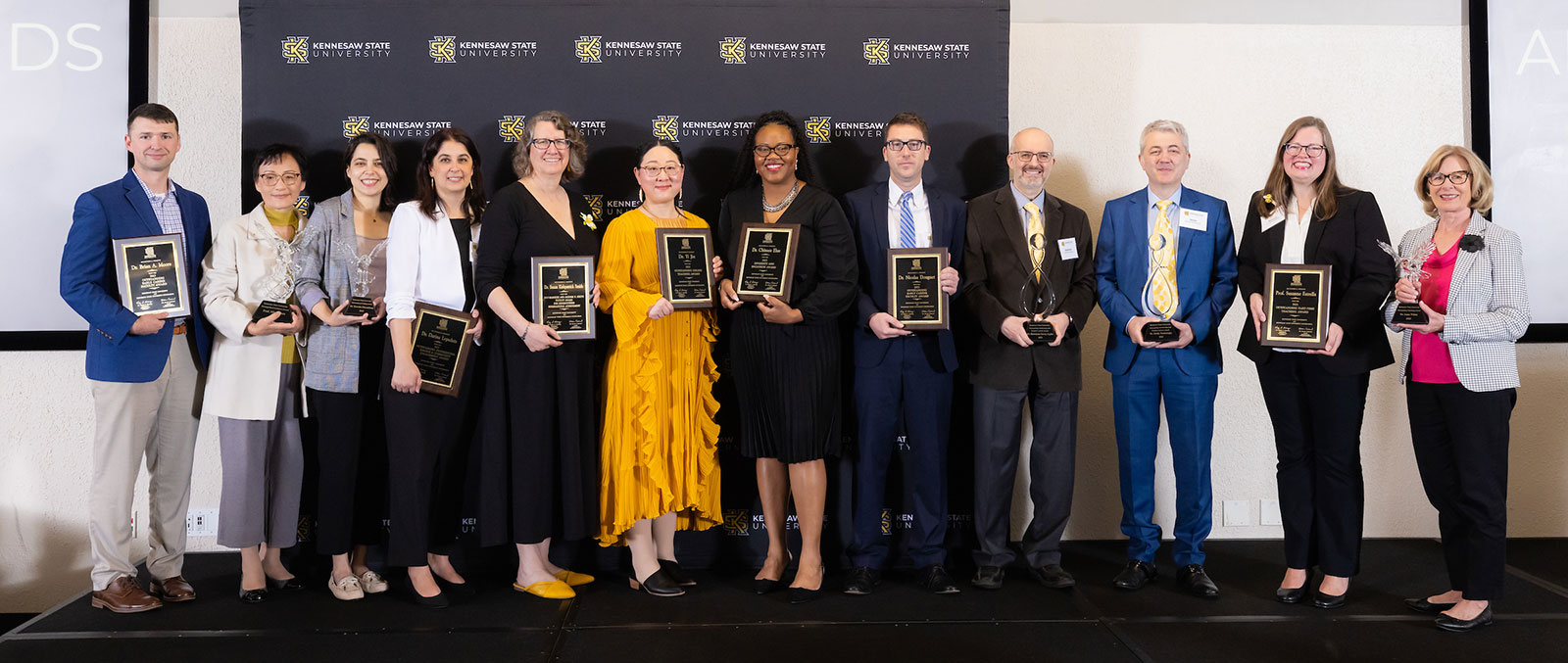 Photo of honorees, picture from left to right are Brian Moore, Ming Chen, Karolin Mirzakhan, Darina Lepadatu, Susan Kirkpatrick Smith, Yi Jin, Chinasa Elue, Nicolas Douguet, Ramazan Aygun, Melih Madanoglu, Susanne Estrella, Anne White