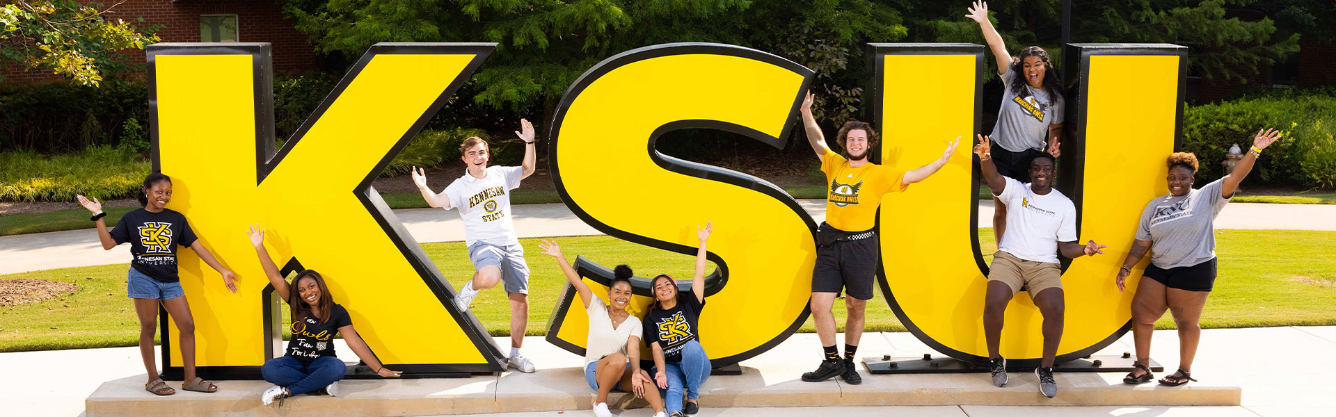 group of ksu students taking a picture in front of the KSU letters.