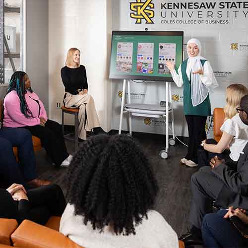 business student presenting to a small group of students.