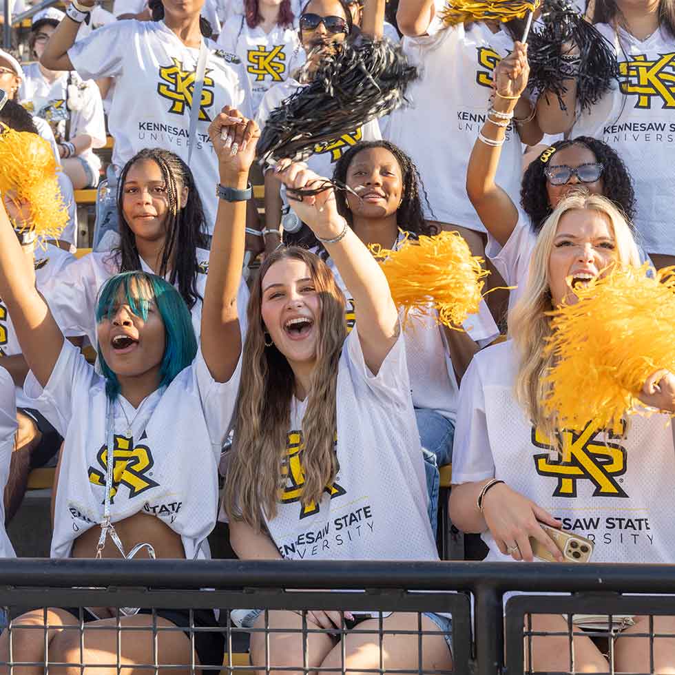 group of excited students cheering for the football team.