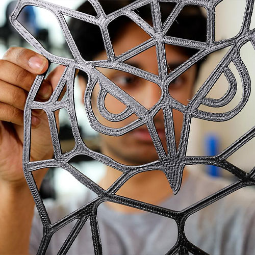 ksu student holding their 3d printed owl.