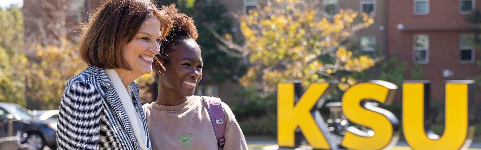 ksu president Kat Schwaig taking a picture with a student on campus.