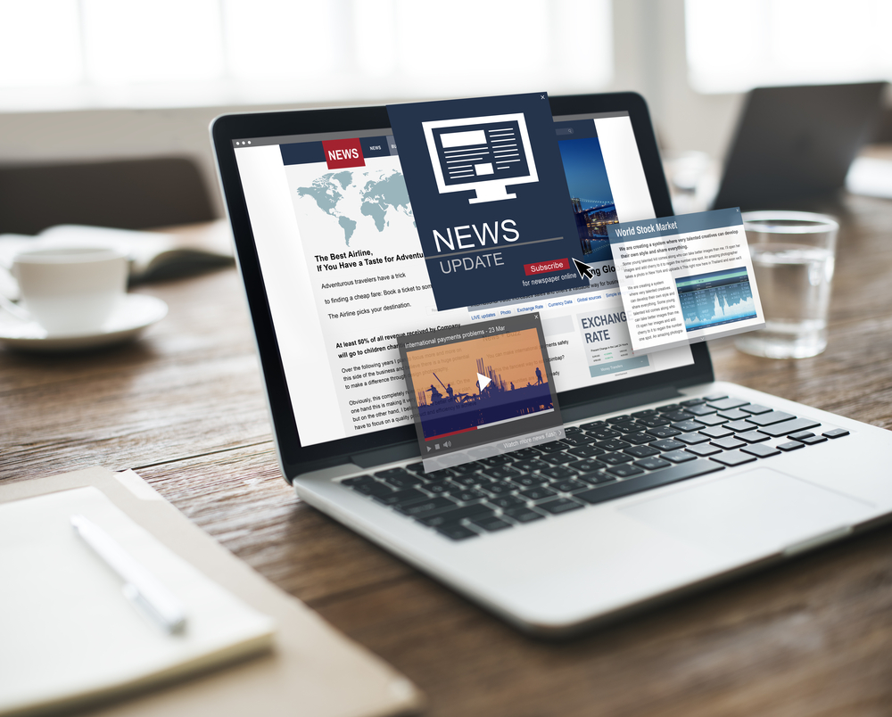 Laptop with many windows open showing news articles
