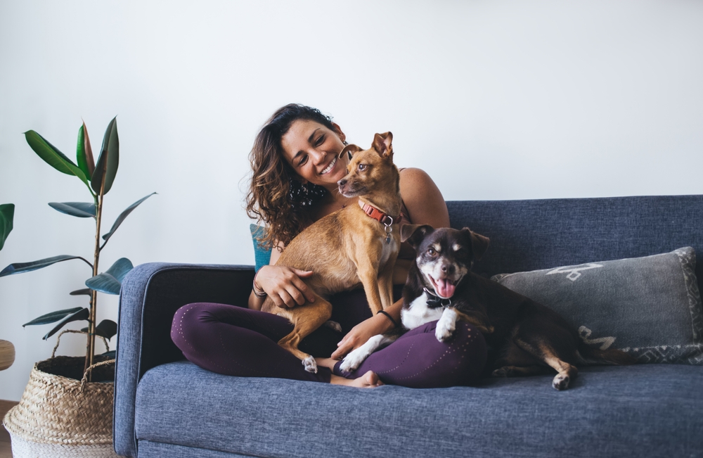 women on couch with two dogs