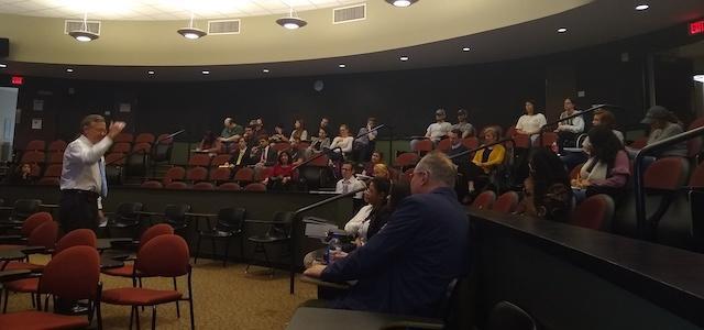  / room full of students listening to speaker
