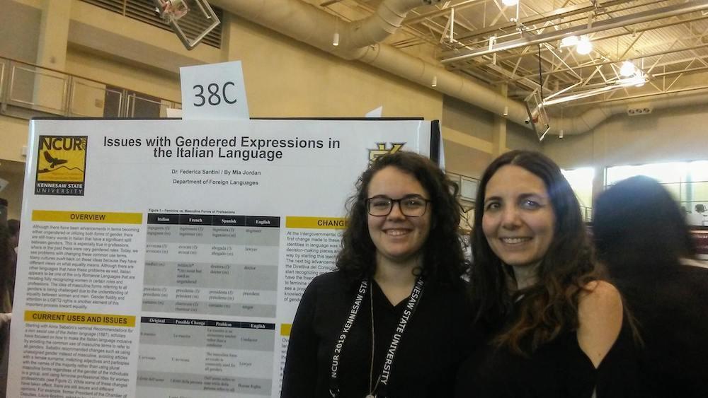 / two undergrad presenters in front of presentation poster