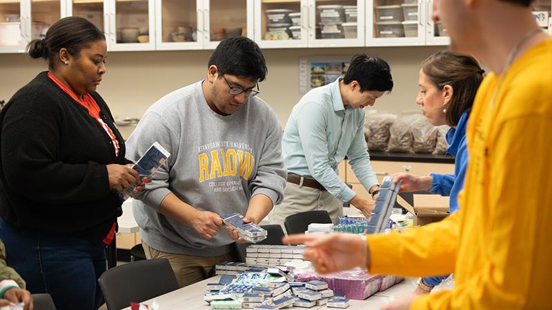  / a group of students at a donation drive, working at a table to package goods
