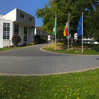 A large building adorned with flags, surrounded by a well-maintained grassy area.