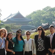 KSU students posing outside in front of a building and trees.