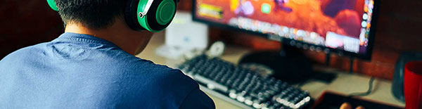 player at computer with headphones on