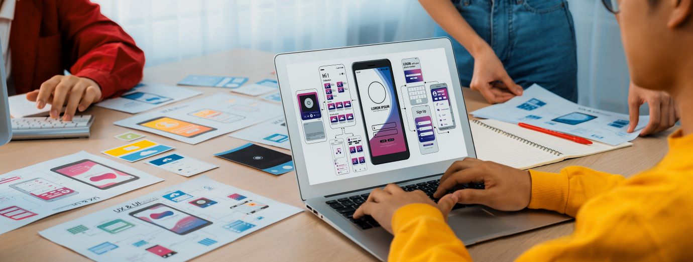 Designers collaborating on mobile app wireframes and UI prototypes.