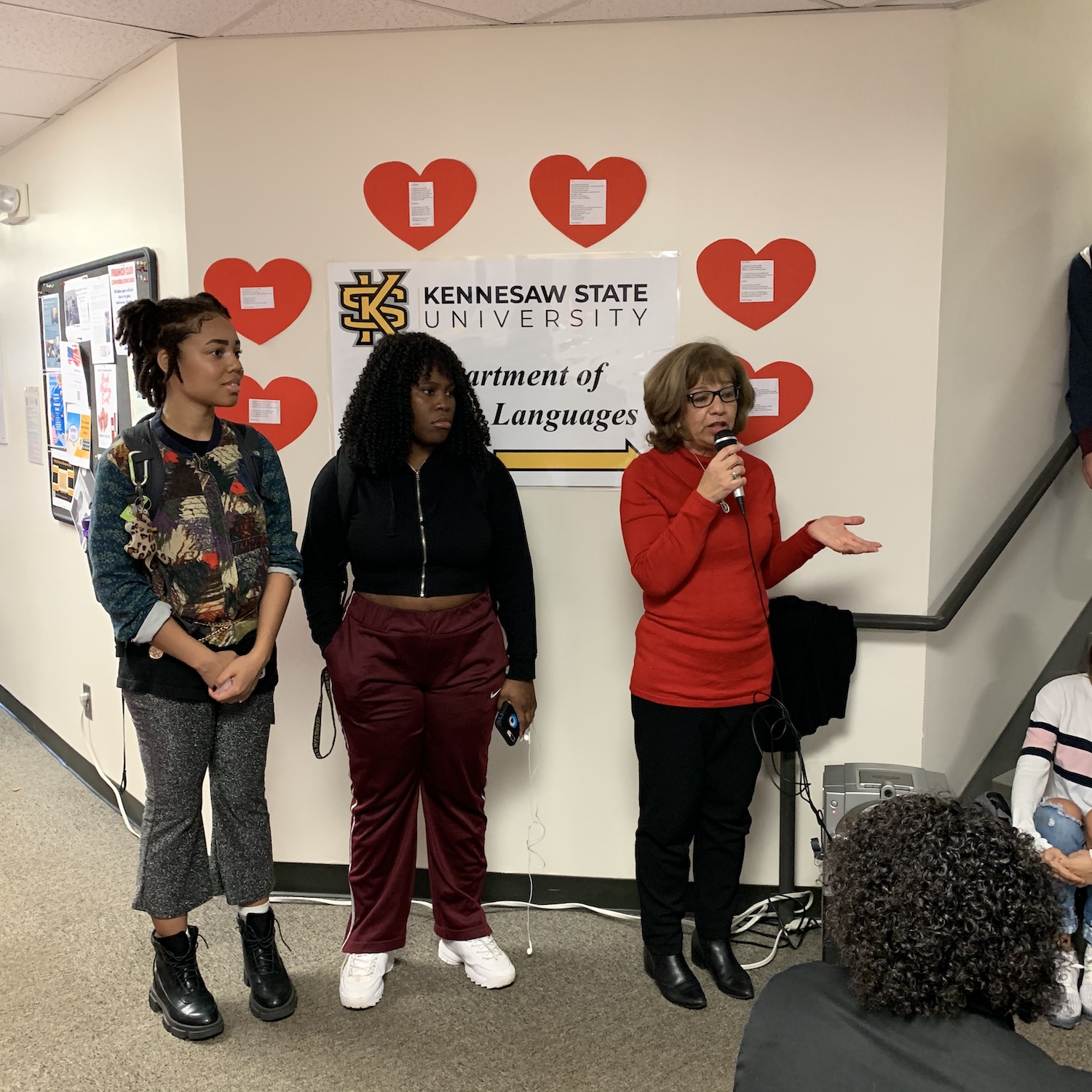 Patricia Wood (L) MCs Presents Two Spanish Student to Read a Poem about Friendship