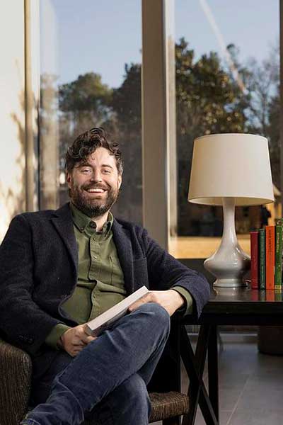 writer sitting in chair with book