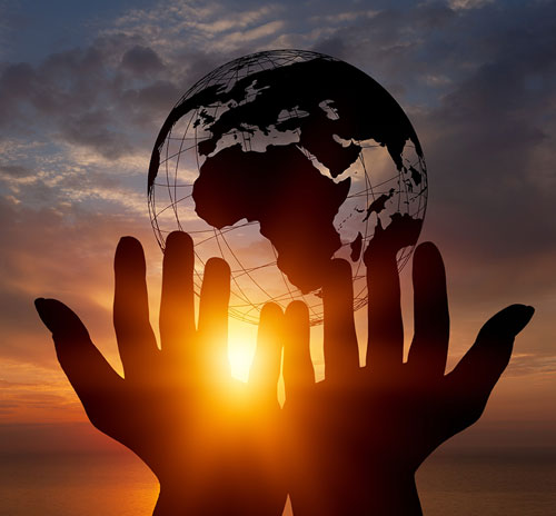 Hands elevate the Earth before a sunset, illustrating the spiritual connection between humanity and the planet in religious studies.