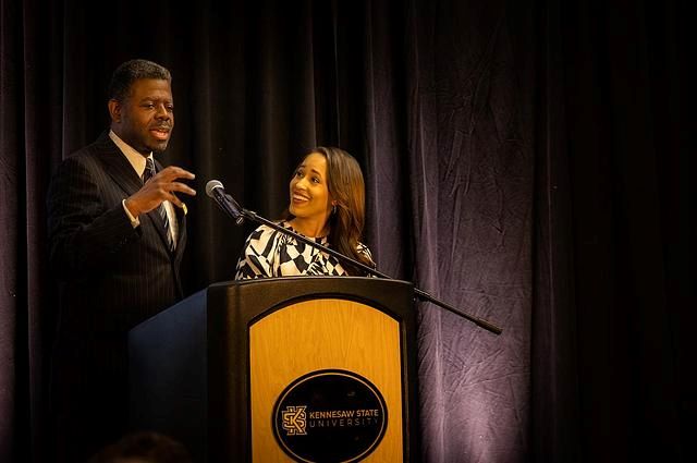 Two speakers standing at a podium with the Kennesaw State University logo on it