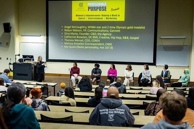 Panel of women speakers at a 'Professionals With Purpose' event in a lecture hall.