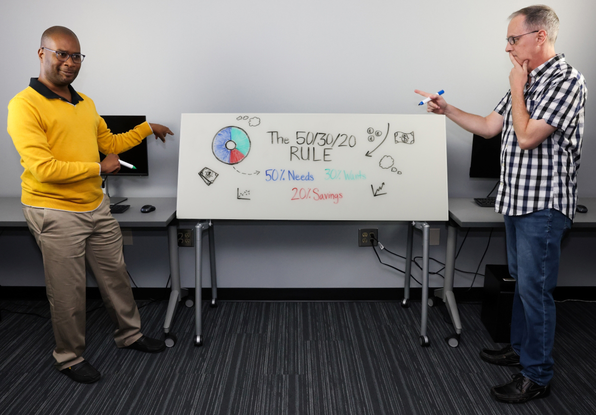 Image of two faculty at a whiteboard