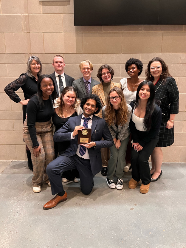 The 2023-2024 Academic Year Mocking Owls pose for a photo with their advisor and Professor of Political Science Elizabeth Gordon, Ph.D., (back left) in celebration of a successful mock trial competition.