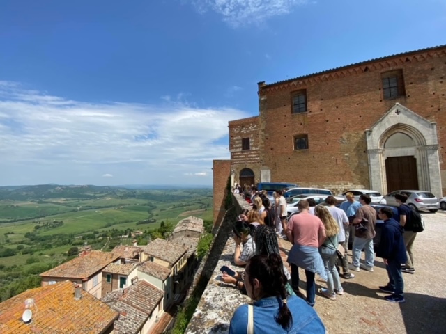 Students standing on a hilltop, enjoying a panoramic view of the lush countryside below.