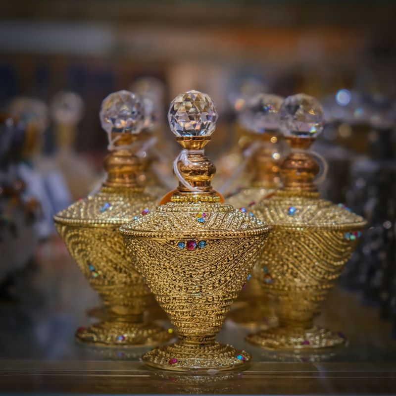Luxurious gold-plated perfume bottles with intricate designs and crystal tops